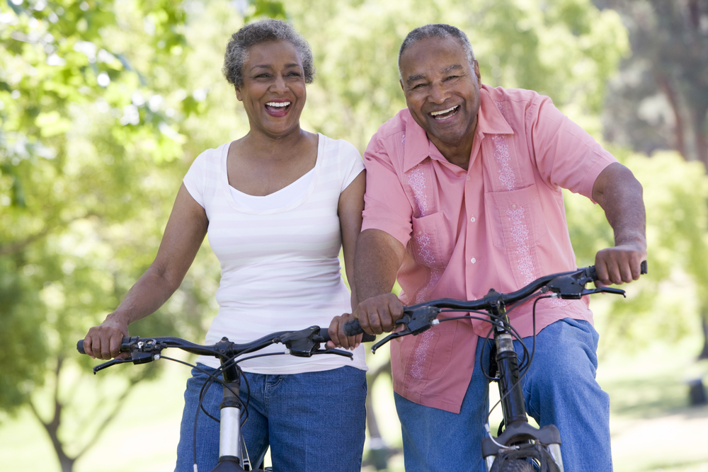 Active couple riding their bikes in the outdoors indicating health after wound care treatments